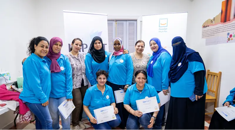 Women proudly holding their sewing certificates