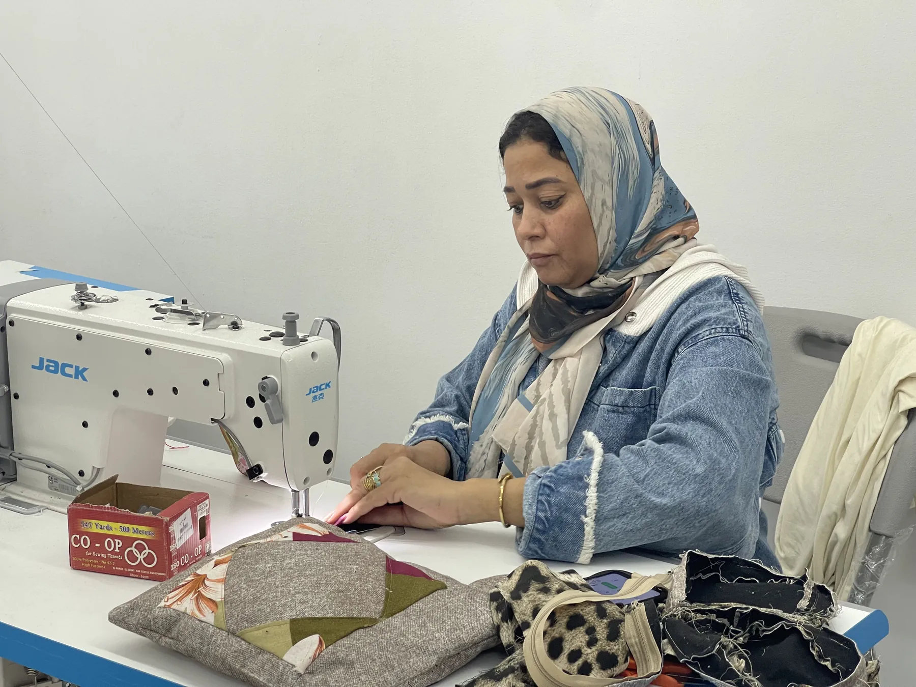 A trainee works at an industrial sewing machine in Alexandria
