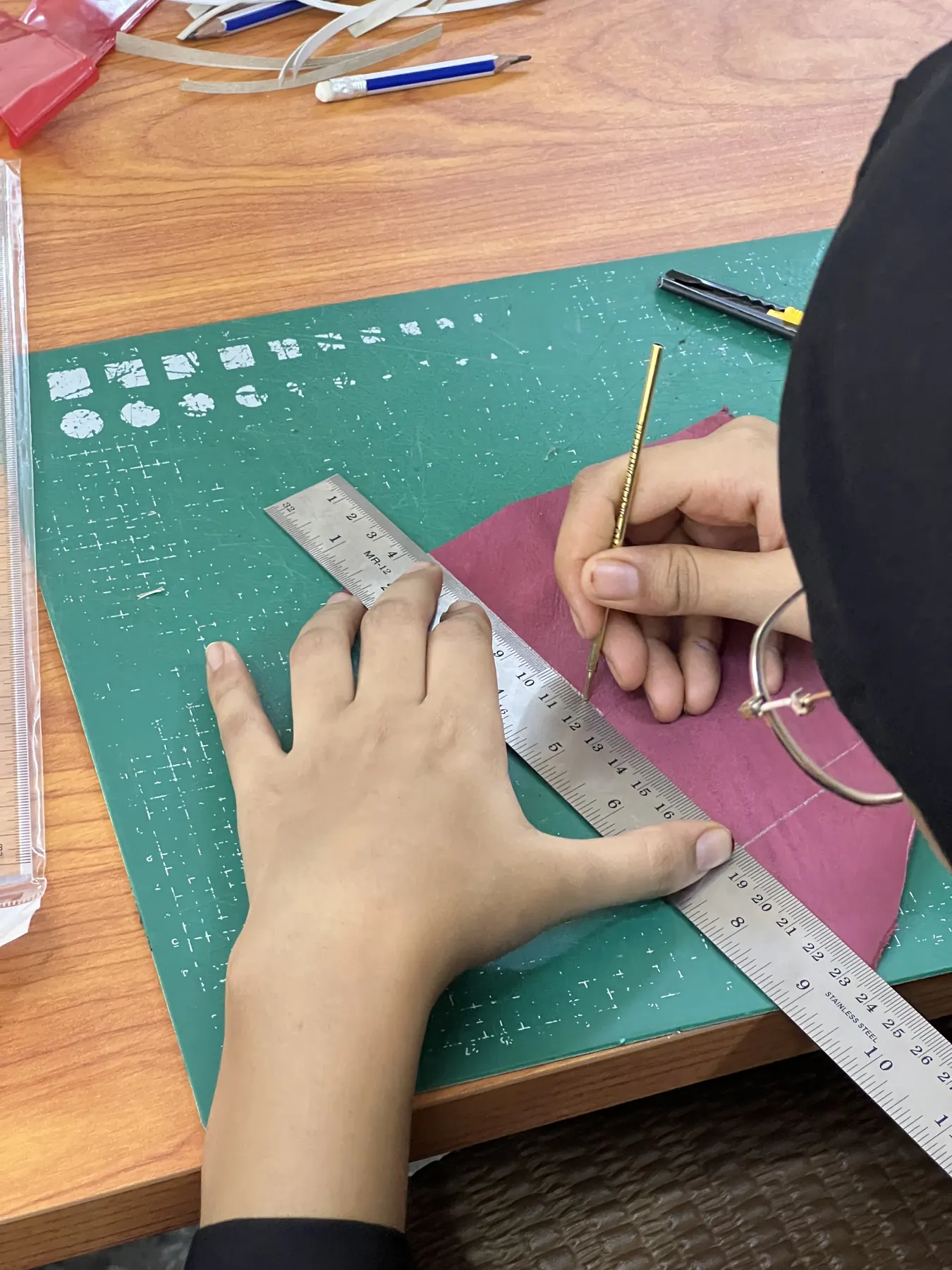 A trainee measures and cuts leather in Aswan