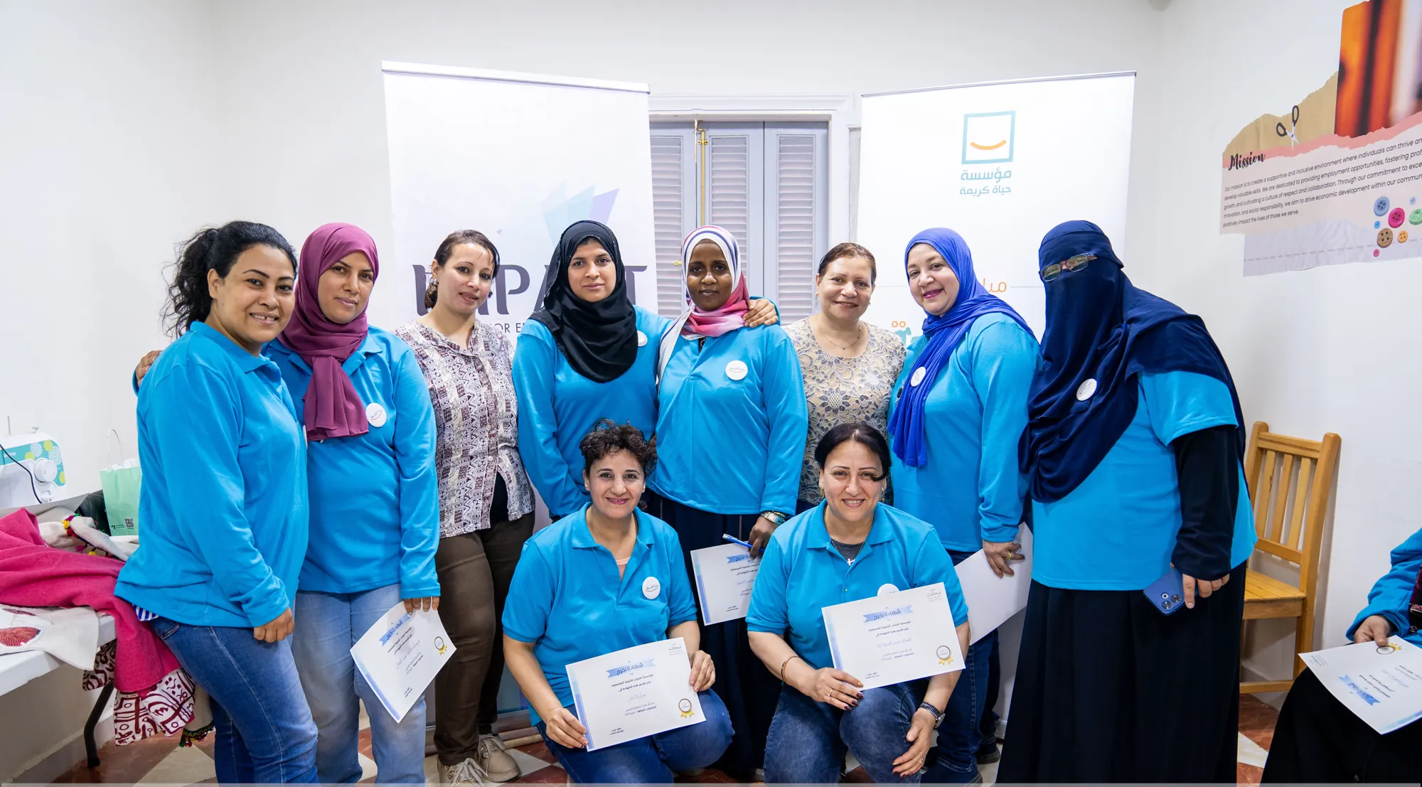 Women proudly holding their sewing certificates